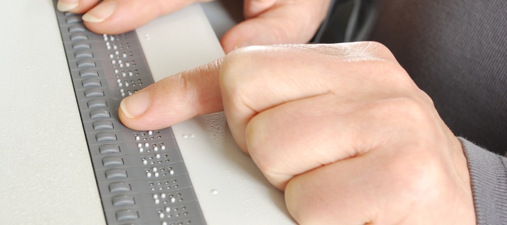 Ligne braille - source Adobe Stock © elypse Doigt parcourant les picots sur une ligne braille.